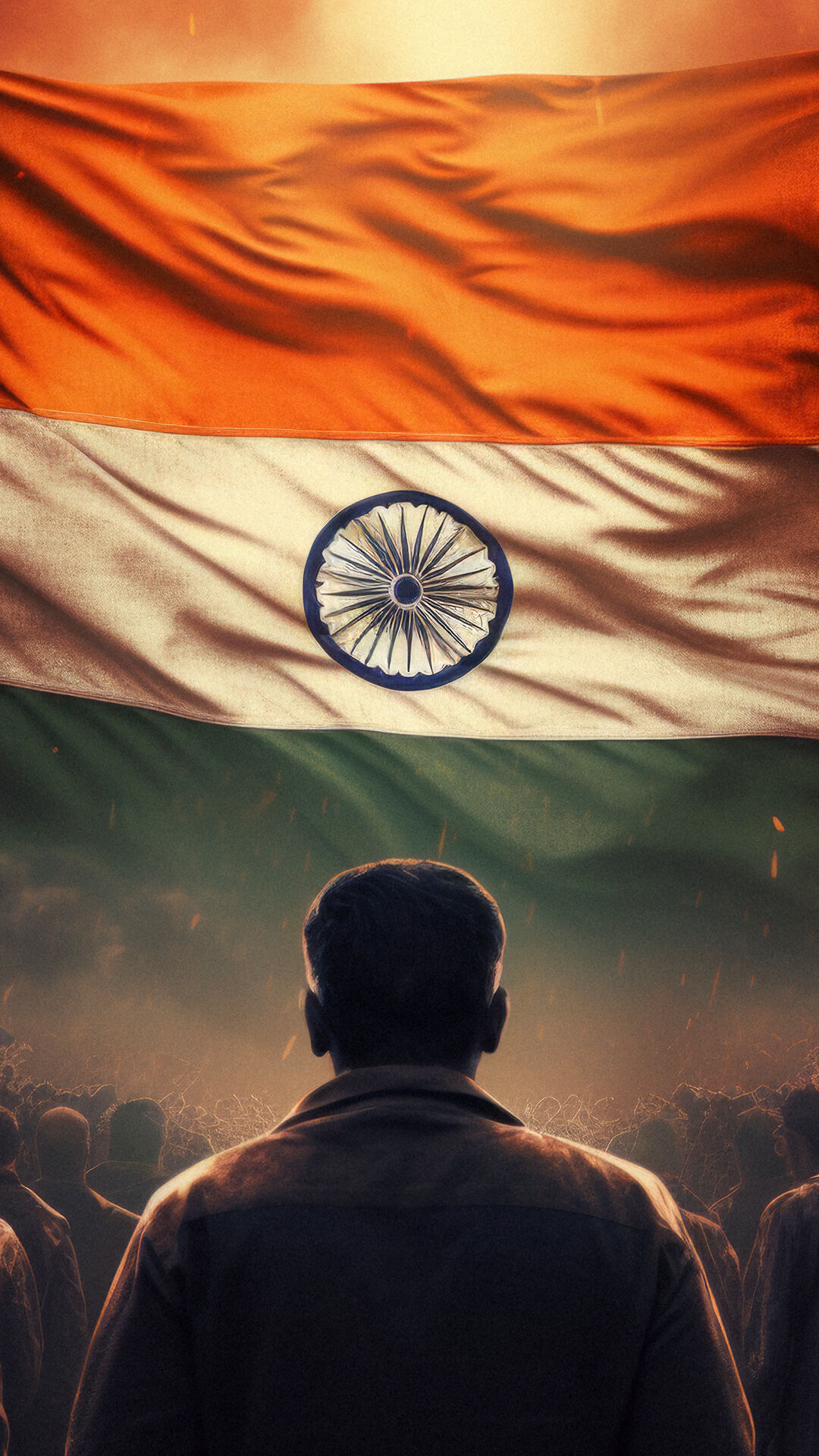 A man stands in the foreground facing a large crowd, with the Indian national flag&rsquo;s tricolor&mdash;orange, white with the Ashoka Chakra, and green&mdash;looming prominently above, symbolizing patriotism and unity.